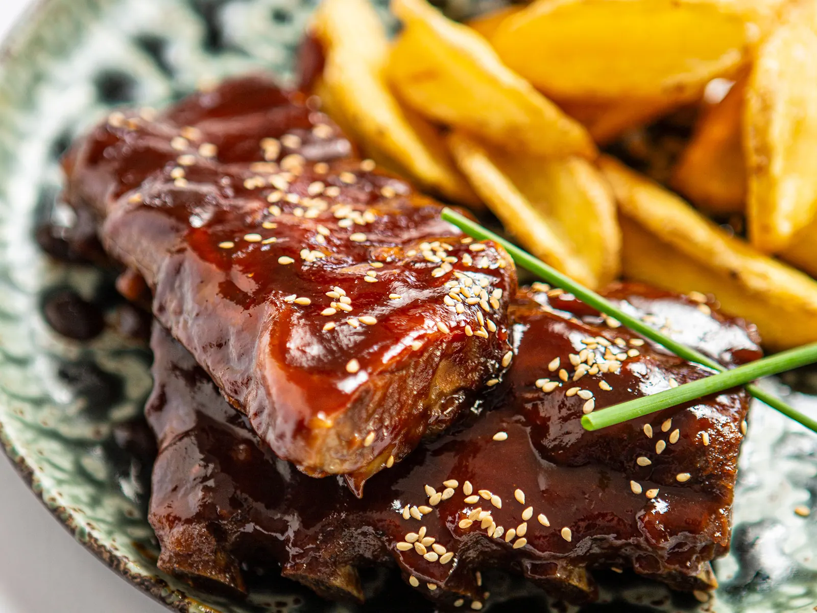 Costillar de cerdo BBQ con sésamo y patatas especiadas