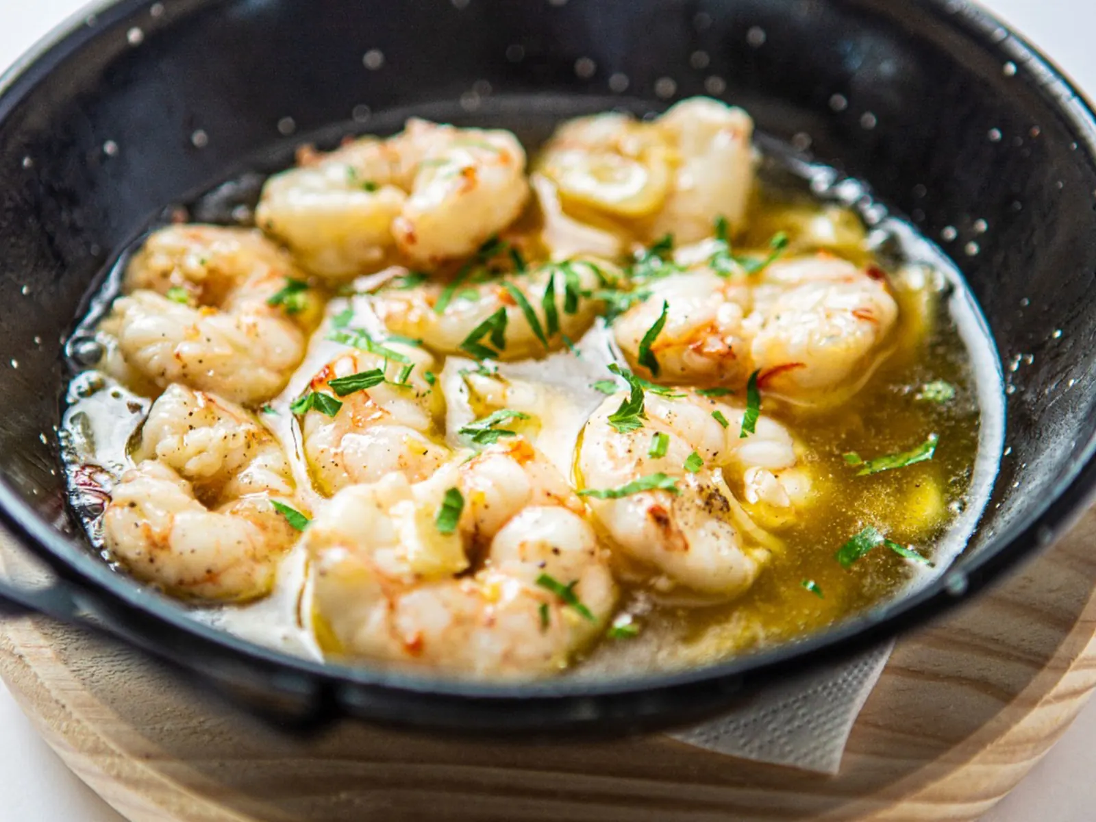 Gambas al ajillo servidas en sartén de hierro